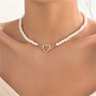 Vue rapprochée d'un collier en perles avec pendentif cœur en finition dorée porté sur un cou féminin - Milanoza