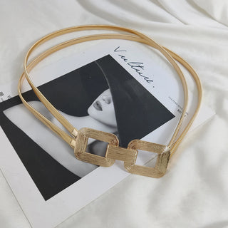 Détail des boucles texturées de la ceinture dorée élégance sur un fond avec image de magazine - Milanoza