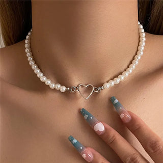 Collier ras du cou en perles avec pendentif argenté en forme de cœur, mise en scène sur un fond de peau claire - Milanoza